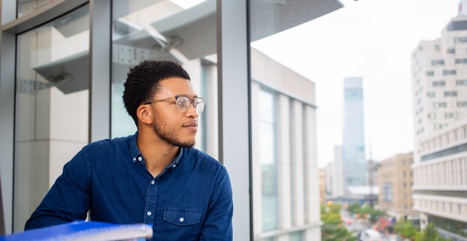 Dornsife student looks out at campus with Philly skyline in background